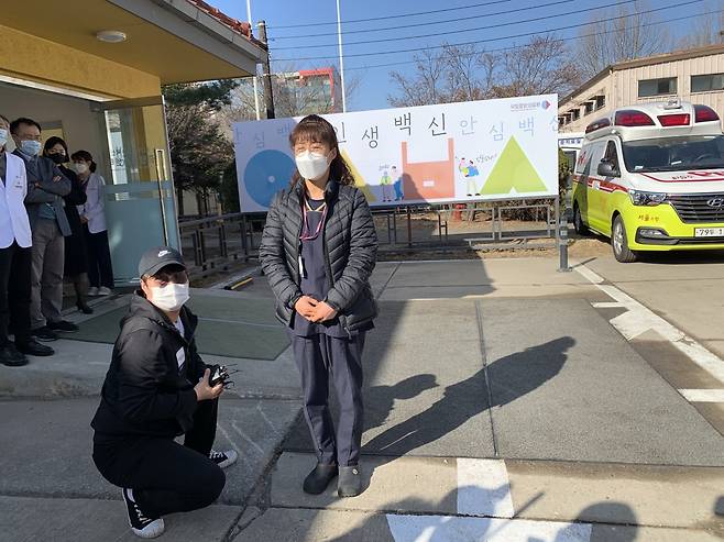 Jung Mi-kyung, a cleaning staffer at the National Medical Center, (center) became the first Korean to receive a Pfizer vaccine Saturday morning. (Kim Arin/The Korea Herald)