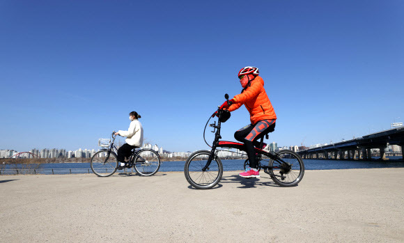 포근한 날씨에 서울 영등포구 여의도한강공원에서 시민들이 자전거를 타고 있다. 연합뉴스