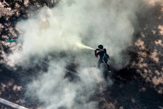 시위대가 2월 28일 군경에 대해 소방기를 분사하고 있다.(사진=AFP)