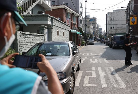 지난해 7월 서울시 공무원들이 강남구 일대 어린이보호구역 내 불법 주차를 단속하고 있는 모습. 연합뉴스