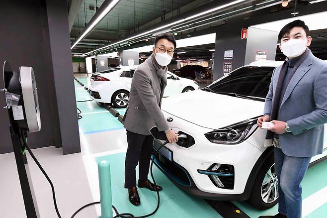 Officials are charging an electric vehicle from an EV charger installed at Homeplus Gangseo branch in Seoul. (Homeplus)
