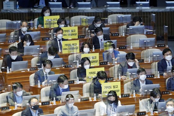 정의당 의원들이 지난달 26일 가덕도 관련 법안을 비판하는 피켓을 의석에 붙여 놓고 있다. 연합뉴스