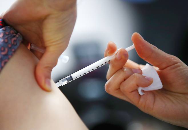 A medical staff inoculates an official with an AstraZeneca vaccine at a senior nursing center in Seoul on Tuesday. (Yonhap)