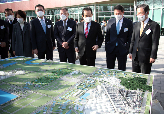 Prime Minister Chung Sye-kyun, third from right, looks at a model of a hydrogen plant at the factory of SK Incheon Petrochem on Tuesday, with SK Chairman Chey Tae-won, second from right, and Hyundai Motor Chairman Euisun Chung, fourth from right.