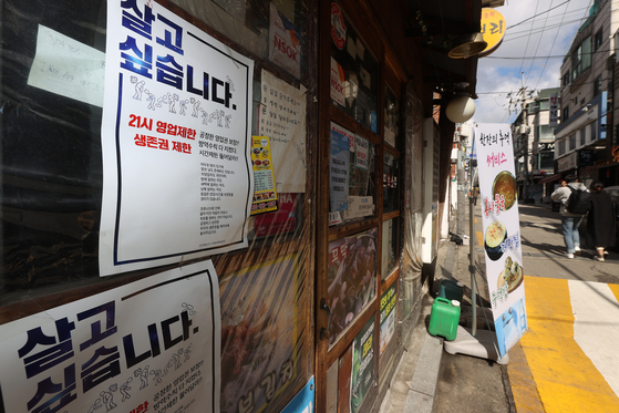 A poster for a restaurant in Seoul says it is difficult for small businesses to survive due to social distancing measures in place because of Covid-19, on Tuesday. [YONHAP]