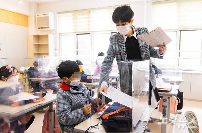 2일 오전 서울시 강남구 포이초등학교에서 첫 등교를 한 1학년 학생들이 담임교사로 부터 알림장을 받고 있다. 사진공동취재단