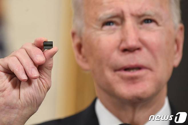 조 바이든 미국 대통령이 지난달 24일 워싱턴 백악관에서 반도체 등 핵심 품목의 공급망을 확보하는 내용의 행정명령에 서명을 하기 전에 반도체 칩을 들고 연설하고 있다. © AFP=뉴스1 © News1 우동명 기자