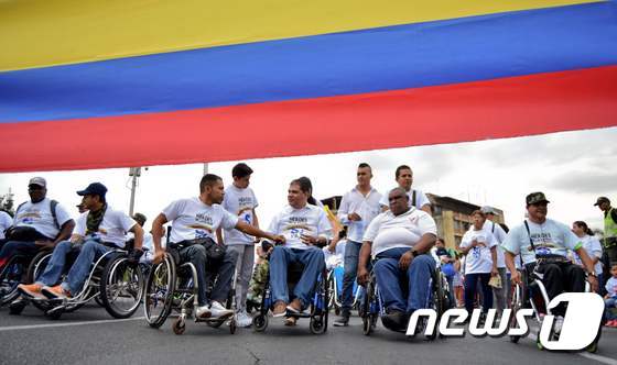 2016년 8월 콜롬비아 바예델카우카 주 칼리에서 정부와 FARC 죄익 게릴라 사이의 평화협정을 지지하는 내전 부상 군인, 경찰들이 휠체어를 타고 행진을 하고 있다.© AFP=뉴스1 © News1 우동명 기자