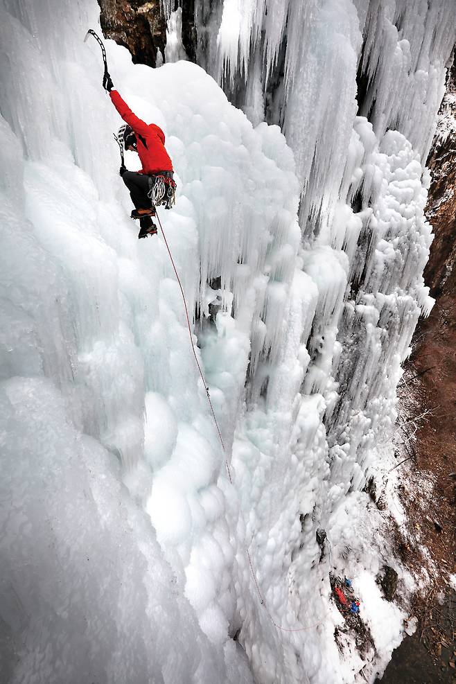 빙벽 중단을 부드러운 무브로 오르는 등반가 공병호씨.  그의 몸에는 가늘고 긴 붉은 줄이 까마득하게 이어져 있다.