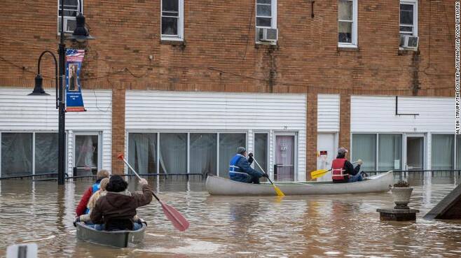 홍수가 난 도시를 보트로 이동하는 미국 켄터키주 주민들
