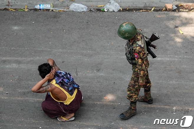 3일 미얀마 군인이 반쿠데타 시위자의 뒤에 서 있다. © AFP=뉴스1