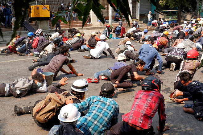 미얀마 제2의 도시 만달레이에서 3일(현지시간) 군부 쿠데타 규탄 시위대가 진압 경찰이 쏘는 총알을 피해 땅에 엎드려 있다.     만달레이｜로이터연합뉴스