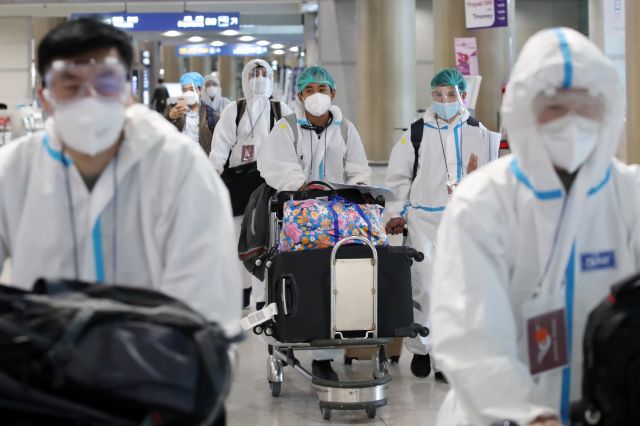 영종도 인천국제공항에서 방역복을 입은 해외 입국자들이 임시 격리시설로 향하고 있다. 연합뉴스