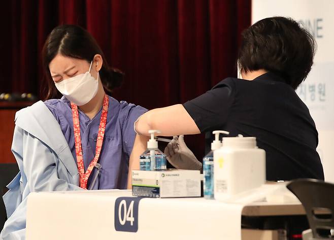 A health worker receives the first dose of the AstraZeneca COVID-19 vaccine Thursday at the Myongji Hospital vaccination center. (Baek So-ah, staff photographer)
