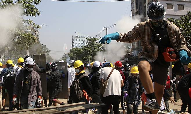 7일(현지시간) 미얀마 양곤에서 군부 쿠데타 반대 시위대가 시위 진압 경찰이 최루탄을 발사하자 이를 피하기 위해 흩어지고 있다. 양곤=AP뉴시스