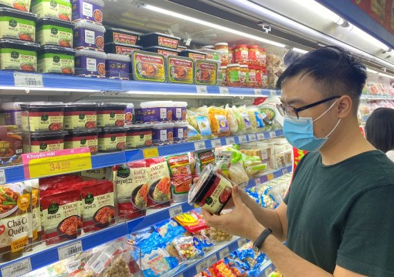 베트남 소비자가 마트 내 비비고 김치 판매 코너에서 김치를 살펴보고 있다.