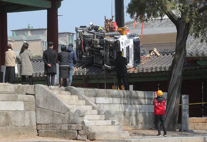 8일 오후 서울 종로구 성균관대 문묘 동삼문 지붕 위에 떨어진 사다리차를 들어내기 위한 작업이 이뤄지고 있다. 연합뉴스