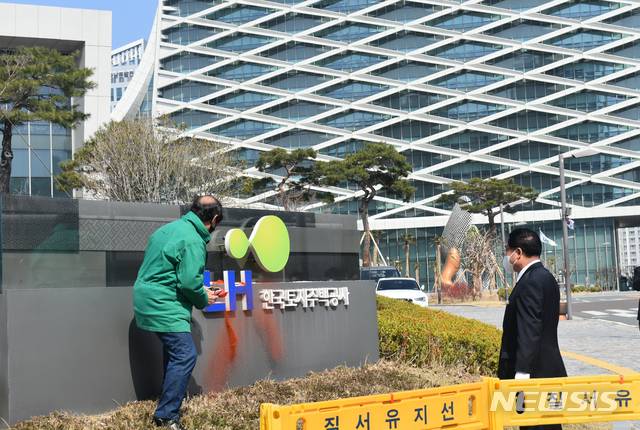 홍정식 활빈단 시민단체 대표가 지난 8일 경남 진주 LH 본사에서 입간판 구조물에 고추가루를 뿌리며 시위하고 있다./사진=뉴시스