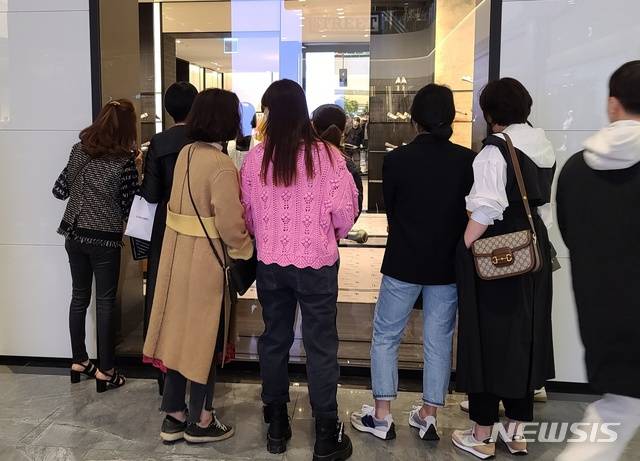 [대구=뉴시스]김정화 기자 = 대구 신세계백화점 샤넬 매장 오픈 첫날인 12일 오전 고객들이 유리 창문을 통해 샤넬 매장을 구경하고 있다 2021.03.12. jungk@newsis.com