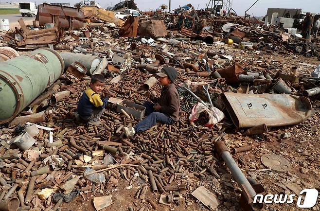 내전으로 폐허가 된 시리아의 한 지역에 아이들이 앉아있는 모습. © AFP=뉴스1