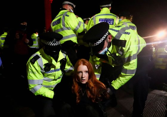 영국 런던 경찰이 집회 해산 명령에 응하지 않은 한 여성을 무력으로 진압하고 있다. [로이터=연합뉴스]