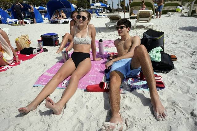 지난 2일(현지시간) 봄방학을 맞아 플로리다 클리어워터 비치를 찾은 대학생들이 앉아있다. AP연합뉴스