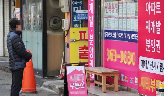 서울 서대문구의 한 부동산 사무실 앞에서 한 시민이 인근 아파트들의 매매와 전세, 월세 가격을 살펴보고 있다. <연합뉴스>