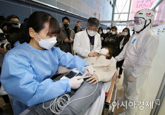 17일 오전 충남 천안시 서북구 실내테니스장에 마련된 예방접종센터에서 실시된 지역 예방접종센터 모의훈련에서 이상반응 발생으로 응급처치실로 이송된 접종대상자를 의료진이 진찰하고 있다./사진공동취재단