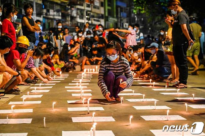 14일(현지시간) 미얀마 양곤에서 군사 쿠데타를 규탄하는 집회 중 시민 시민들이 촛불을 놓고 있다. © AFP=뉴스1 © News1 우동명 기자