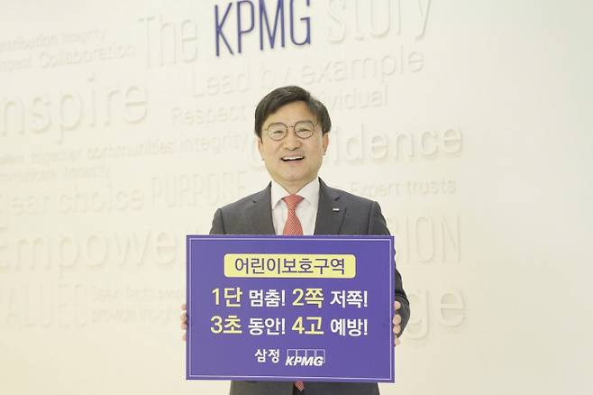 구승회 삼정KPMG 재무자문부문 대표가 어린이 교통안전 슬로건을 들고 기념촬영을 하고 있다. <사진=삼정KPMG>