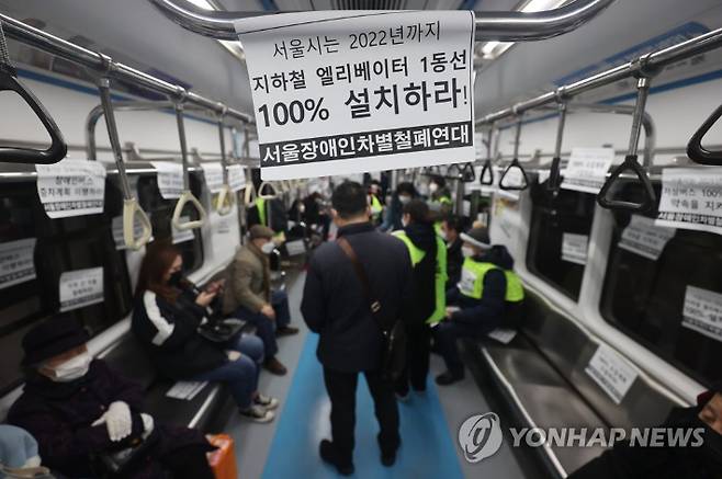 (서울=연합뉴스) 임화영 기자 = 서울장애인차별철폐연대 회원들이 10일 오후 서울 지하철 4호선 명동역 열차 내에 장애인 이동권 보장을 요구하는 문구가 적힌 종이를 붙여놨다. 지하철 4호선 종점인 당고개역에서 이날 오후 3시 17분께 시작해 두시간 가량 진행된 시위는 서울역에서 종료됐으며, 시위하는 동안 열차 운행이 지연됐다. 2021.2.10 hwayoung7@yna.co.kr 연합뉴스