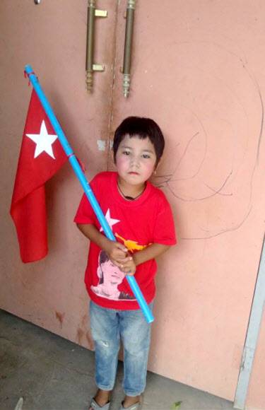 지난 23일(현지시간) 미얀마 만달레이의 집안을 뒤지던 경찰의 잔인한 총질에 희생된 일곱 살 소녀 킨 묘 칫이 국기를 든 채 카메라 앞에 포즈를 취하고 있다.킨 묘 칫 가족 제공 로이터 연합뉴스