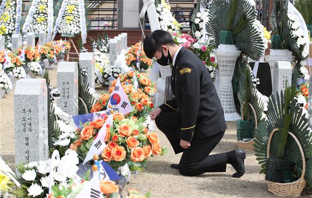 천안함 46용사 묘역에서 고인 애도하는 군사학과 학생 - 서해수호의 날인 26일 오전 대전 유성구 국립대전현충원 천안함 46용사 묘역을 찾은 대덕대 군사학과 학생이 참배하고 있다. 2021.3.26 뉴스1