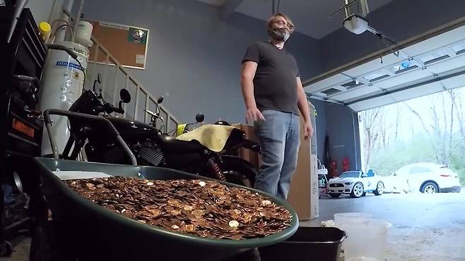 마지막 월급 약 100만 원을 기름 투성이 동전으로 받은 남성 엔드레이어스 플래턴의 모습.