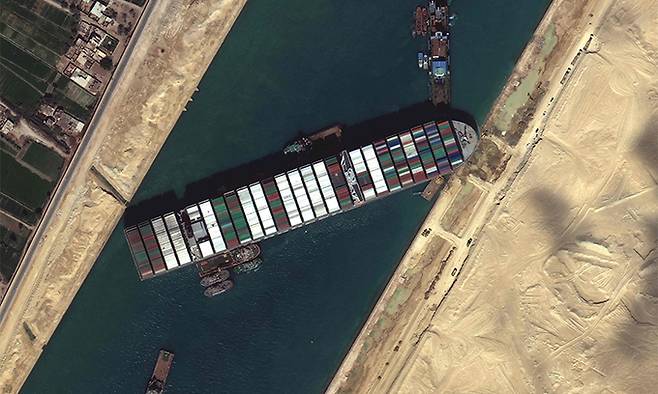 파나마 선적의 길이 400m 초대형 컨테이너선 '에버 기븐'호가 지난 27일(현지시간) 수에즈 운하의 통행을 닷새째 가로막고 있는 모습을 보여주는 위성사진. 수에즈=AFP연합뉴스