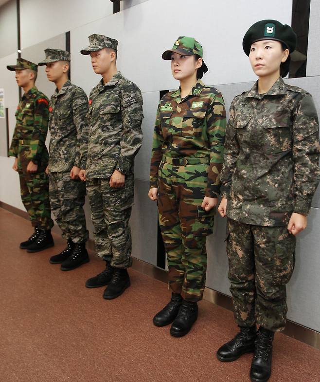 2011년 국방부가 개최한 디지털 무늬 신형 전투복(맨 오른쪽, 육군)과 구형 얼룩무늬 군복(오른쪽에서 두 번째, 일명 ‘개구리 군복’) 비교 설명회. 국방부는 3년간 신형과 구형 전투복을 함께 허용하다 2014년 5월부터는 신형 전투복만 허용했다.