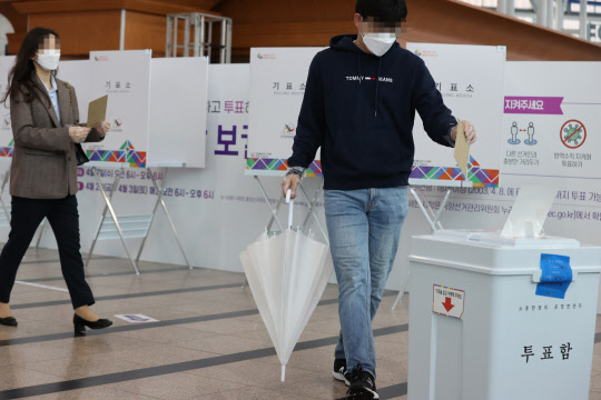 4·7 재보궐선거 사전투표 마지막 날인 3일 오전 서울역에 마련된 남영동 사전투표소에서  한 유권자가 투표용지를 투표함에 넣고 있다. 연합뉴스