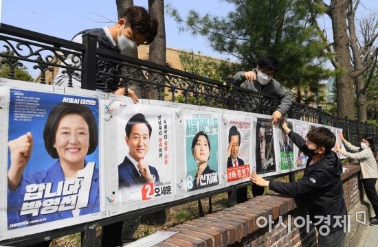 4.7 서울시장 보궐선거 공식 선거운동이 시작된 지난달 25일 서울 종로구 대학로에서 서울시선관위 직원들이 선거벽보를 부착하고 있다./강진형 기자aymsdream@