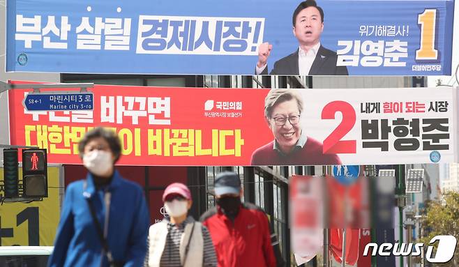 (부산=뉴스1) 여주연 기자 = 4·7재보궐 선거를 일주일 앞둔 31일 오후 부산 해운대구의 한 거리에서 시민들이 부산시장 후보 현수막 앞을 지나고 있다. 2021.3.31/뉴스1