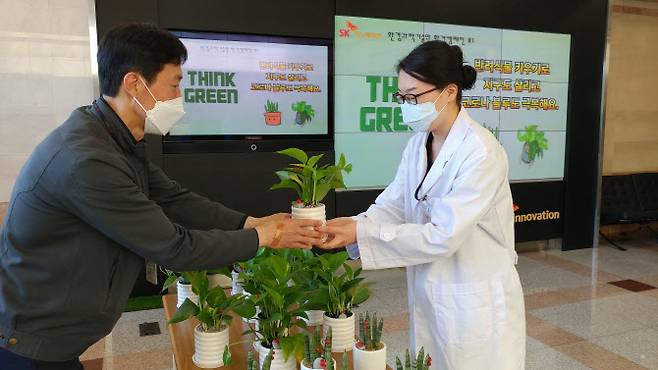 SK이노베이션 환경과학기술원 구성원들이 ‘반려식물 키우기’ 환경캠페인에 참여해 화분을 전달받고 있다. (사진=SK이노베이션)