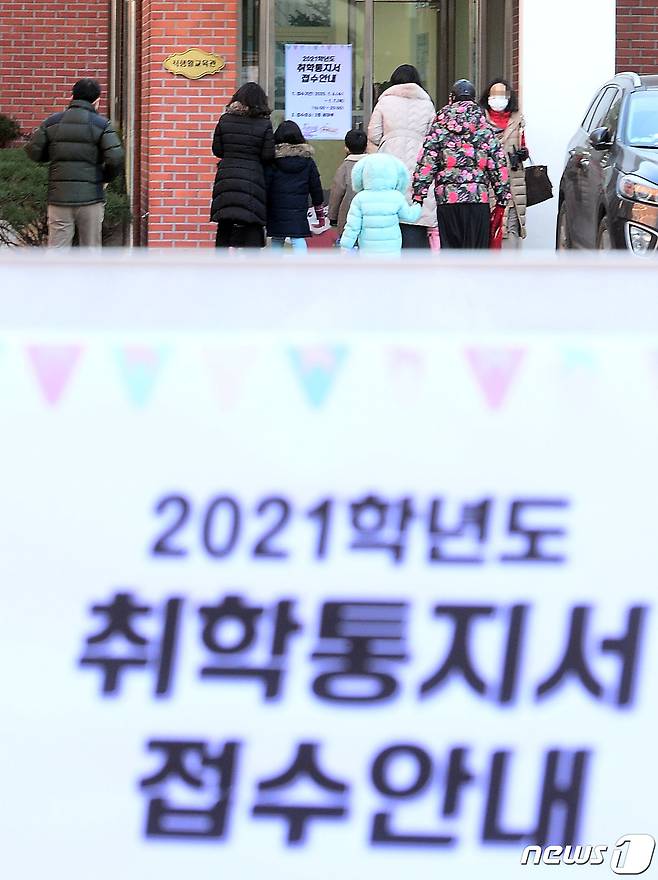 2021학년도 서울 초등학교 신입생 예비소집일인 지난 1월6일 예비 초등학생과 학부모가 입학서류를 작성하기 위해 강당으로 들어가고 있다. 2021.1.6/뉴스1 © News1 사진공동취재단