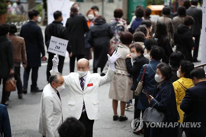 '거리두기' 지켜주세요 (서울=연합뉴스) 박동주 기자 = '코로나19' 사태 이후 두 번째 부활절인 4일 오전 서울 여의도 순복음교회 앞에서 신자들이 부활절 예배를 위해 줄지어 서 있자 교회 관계자들이 '거리두기'를 신도들에게 안내하고 있다. 2021.4.4 pdj6635@yna.co.kr