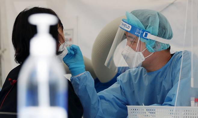 지난 6일 서울 삼성역 임시선별검사소를 찾은 시민이 검사를 하고 있다. 뉴시스