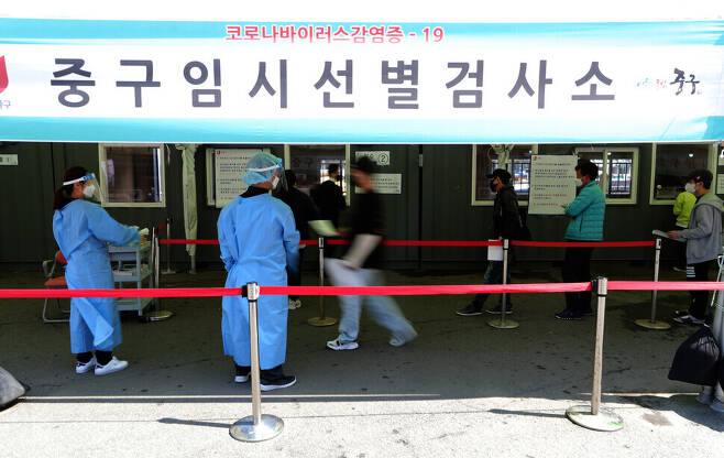 People get tested for COVID-19 Wednesday at a temporary screening center at Seoul Station. (Lee Jong-keun/The Hankyoreh)