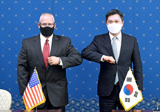 Kim Sang-jin, director general of the Korean Defense Ministry's international policy bureau, right, and Maj. Gen. Thomas Weidley of the U.S. Forces Korea bump elbows after the formal signing of the defense cost-sharing deal in Seoul Thursday. [YONHAP]