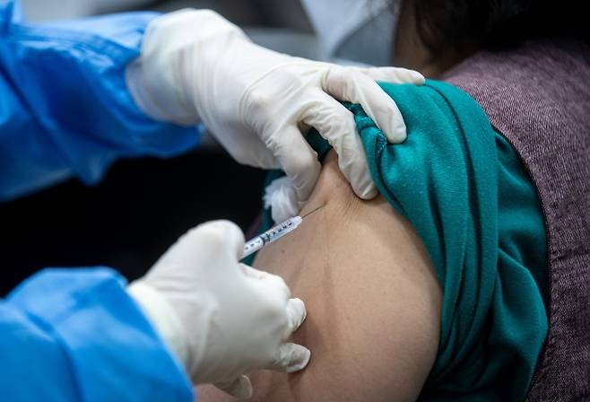 전국적으로 코로나19 백신 접종이 시작된 26일 서울 성동구보건소에서 노인요양시설 요양보호사가 아스트라제네카 백신 접종을 받고 있다. 사진공동취재단