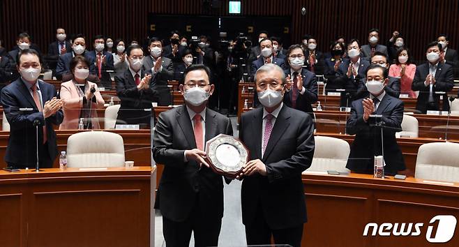 김종인 국민의힘 비대위원장이 8일 서울 여의도 국회에서 열린 국민의 힘 의원총회에서 주호영 원내대표에게 감사패를 받고 있다. 2021.4.8/뉴스1