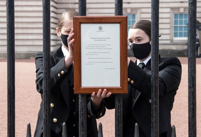 버킹엄 궁전 관계자가 9일 필립공의 별세를 알리는 공고문을 궁전 문에 내걸고 있다. 런던=AFP 연합뉴스