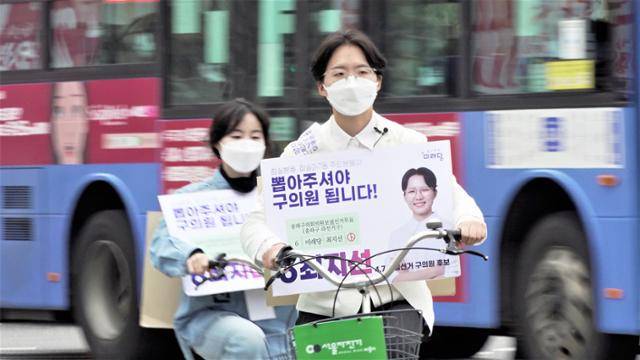 최지선(오른쪽) 미래당 서울 송파구의원 후보가 지난 4일 서울 잠실새내역 인근에서 자전거를 타고 거리유세를 하고 있다. 이수연 PD