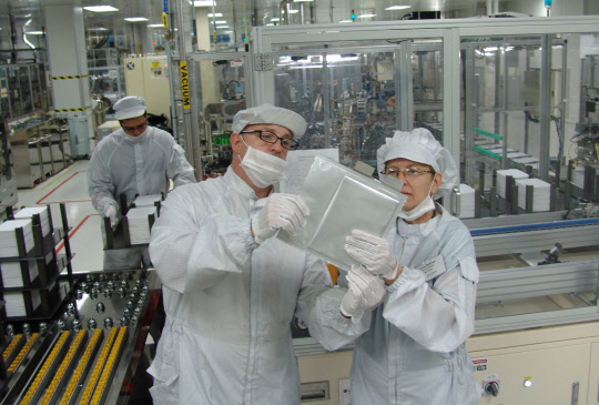 LG에너지솔루션 미국 미시간 공장 생산라인에서 직원들이 중대형 리튬이온배터리 셀을 살펴보고 있다. <LG에너지솔루션 제공>